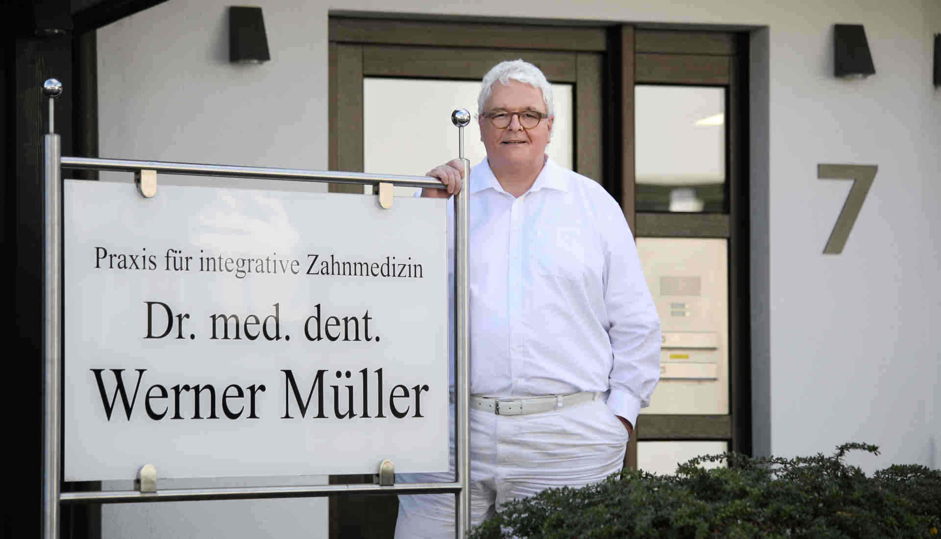 Dr. med. dent. Werner Müller vor Praxis Wewer